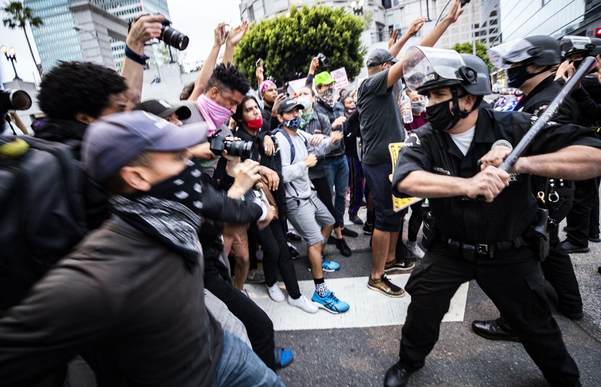 epaselect epa08453509 A police officer reacts as protesters try to break through a police blockade during protests over the Minnesota arrest of George Floyd, who later died in police custody, in Los A ...