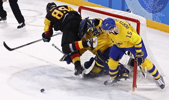 epa06533040 Goalie Jhonas Enroth (C) and Simon Bertilsson (R) of Sweden collide with David Wolf (L) of Germany during their preliminary round match inside the Kwandong Hockey Centre at the PyeongChang ...