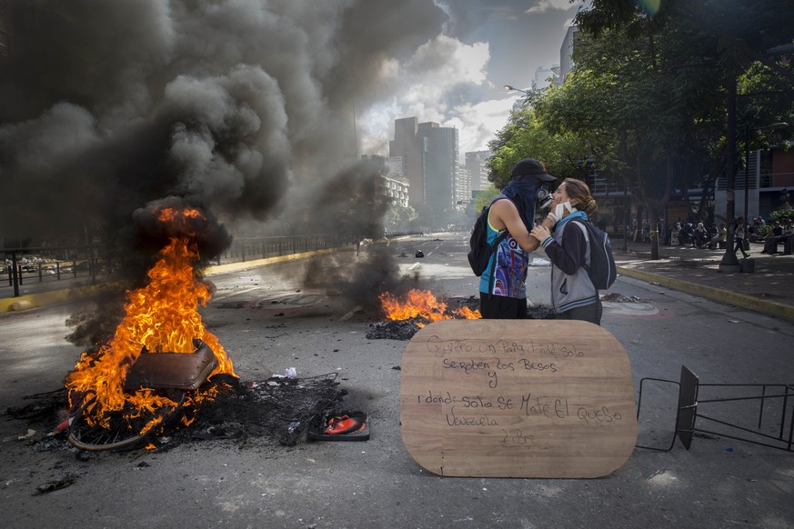 epa06118259 Opposition demonstrators pose kissing during the vote on the National Constituent Assembly, in Chacao, Caracas, Venezuela, 30 July 2017. Clashes are breaking out as the voting on a constit ...