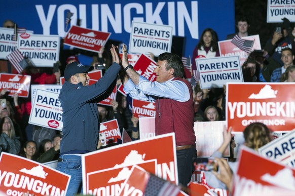 Republican gubernatorial candidate Glenn Youngkin high fives his son Grant, left, after walking onstage to address supporters at a campaign rally in Leesburg, Va., Monday, Nov. 1, 2021. (AP Photo/Clif ...