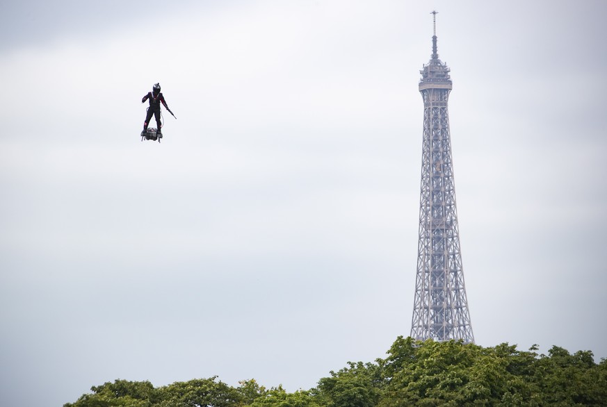 epa07716014 Professional pilot Franky Zapata demonstrates a flight on a &#039;flyboard&#039;, which the French army is considering using for military purposes, during the annual Bastille Day military  ...