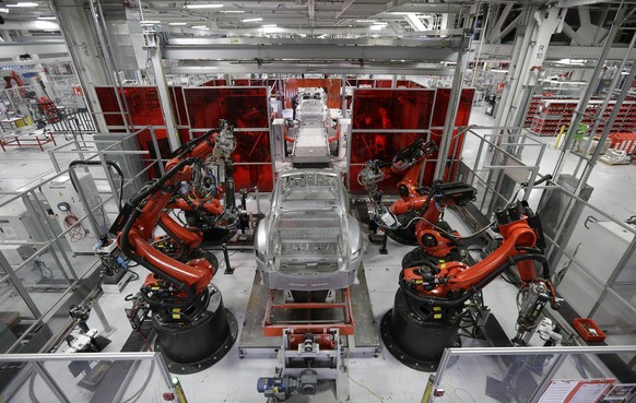 In this May 14, 2015 photo, Kuka robots work on Tesla Model S cars in the Tesla factory in Fremont, Calif. The Institute for Supply Management, a trade group of purchasing managers, issues its index o ...
