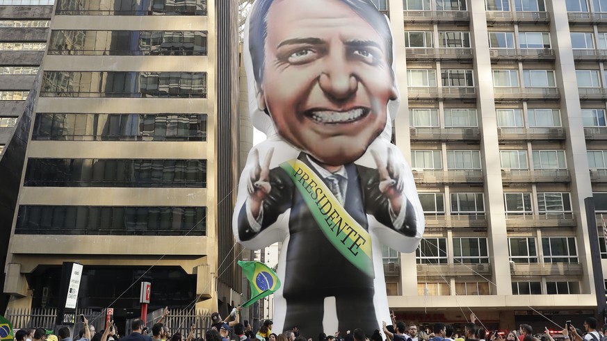 Supporters of Jair Bolsonaro, presidential candidate for the National Social Liberal Party who was stabbed during a campaign event days ago, exhibit a large, inflatable doll in his image as they march ...