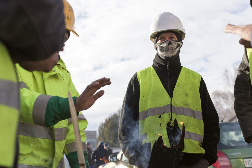 Des ouvriers, accompagnes de membres du syndicat UNIA, bloquent l&#039;entree poids lourds du chantier de l&#039;Hopital Riviera-Chablais ce mardi, 19 decembre 2017 a Rennaz (VD). 16 travailleurs de l ...