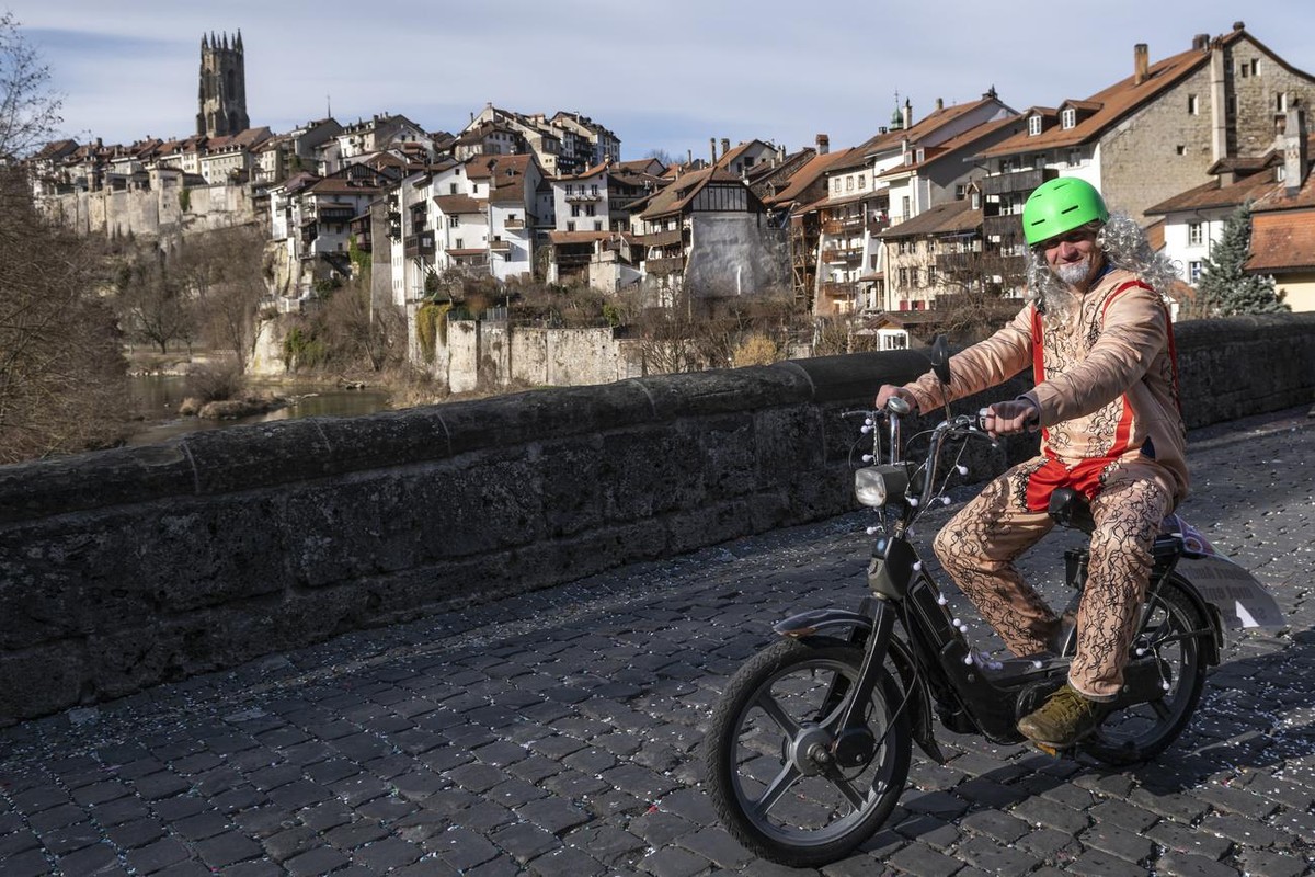 Une personne deguisee en "Hubert Audriaz", artiste fribourgeois, participe au grand cortege du 51eme Carnaval des Bolzes dans les rues de la Basse-Ville de Fribourg, avec la cathedrale St-Ni ...
