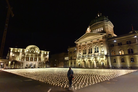 epa09628699 Activists lit almost 12,000 candles in memory of the people who died from COVID-19 in Switzerland, at Bundesplatz (Federal Square) in front of the Federal Palace, in Bern, Switzerland, 07  ...