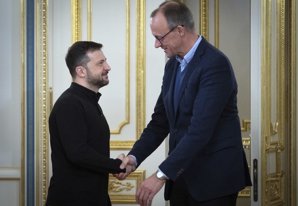 Ukrainian President Volodymyr Zelenskyy, left, and the Chairman of the German Christian Democratic Party (CDU) Friedrich Merz shake hands during their meting in Kyiv, Ukraine, Monday, Dec. 9, 2024. (A ...