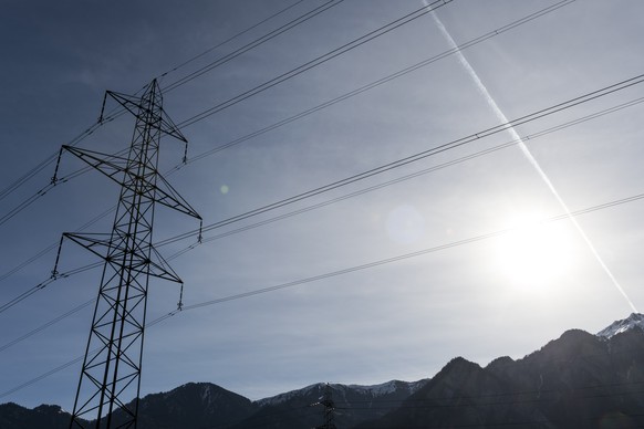 ARCHIV - ZUR MELDUNG, DASS DER ENERGIEKONZERN ALPIQ WIEDER IN DER GEWINNZOHNE IST, STELLEN WIR IHNEN DIESES ARCHIVBILD ZUR VERFUEGUNG - Blick auf einen Strommasten und die Sonne, aufgenommen am Mittwo ...