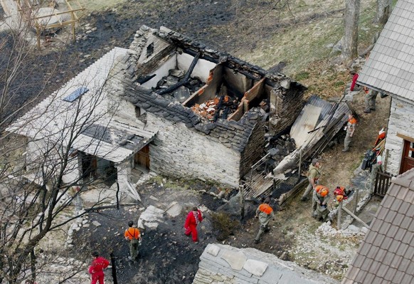 Feuerwehrleute untersuchen am Donnerstag, 25. April 2002, die Ruine eines zerstoerten Rusticos oberhalb von Gordevio im Maggia-Tal. Der am Mittwoch ausgebrochene Waldbrand oberhalb des Dorfes Gordevio ...
