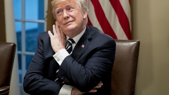 President Donald Trump, center, accompanied by House Ways and Means Committee chairman Rep. Kevin Brady, R-Texas, left, and Rep. Diane Black, R-Tn., right, gestures as he listens to a question from a  ...