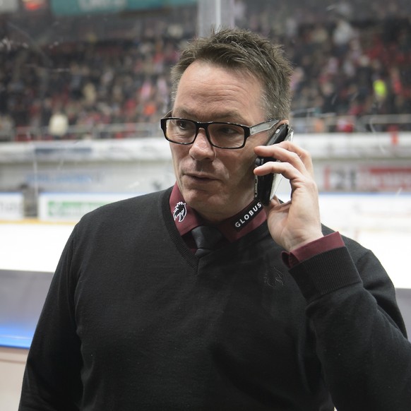 L&#039;entraineur genevois Chris McSorley, parle au telephone apres l&#039;annulation de la rencontre suite a un ecran geant lumineux au milieu de la patinoire, lors du match du championnat suisse de  ...