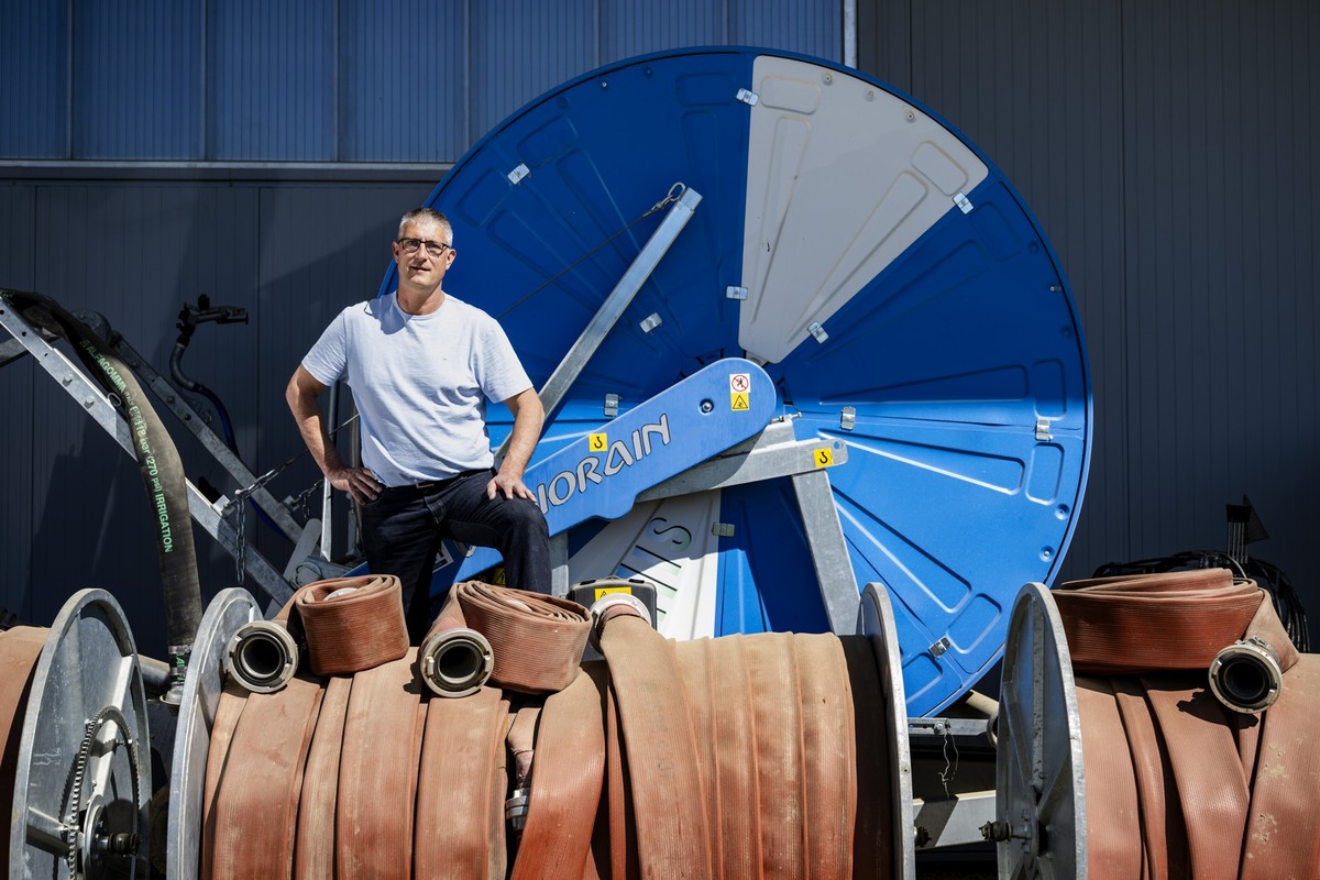 Fabrice Bersier, president de la cooperative ArroBroye pose devant un enrouleur pour tuyau d'arrosage le jeudi 9 avril 2026 a Vesin dans le canton de Fribourg. ArroBroye est un projet d'irri ...