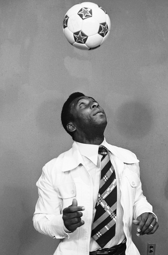 Pele, famous Brazilian soccer player that has joined the New York Cosmos, keeps his eyes on the ball as he demonstrates how to bounce the ball with his hood at news conference held in Philadelphia on  ...