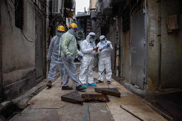 epa08947928 Workers check the sewage of old tenement building where Covid-19 cases have been confirmed in Jordan, Hong Kong, China, 19 January 2021. The government will step up coronavirus Covid-19 testing in Sham Shui Po, Yau Ma Tei and Jordan amid a rise in infections in the three districts.  EPA/JEROME FAVRE