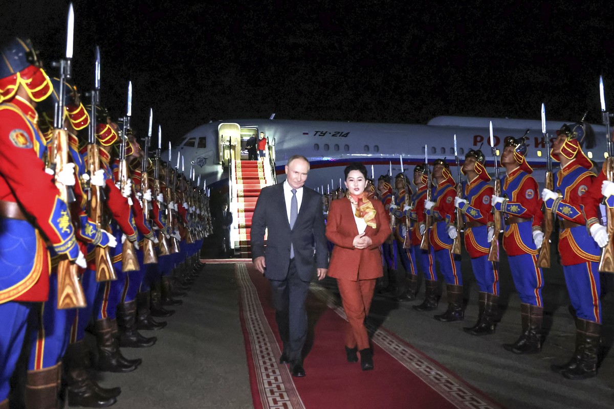 Russian President Vladimir Putin, on red carpet left, walks next to Mongolian Foreign Minister of Mongolia, Batmunkh Battsetseg upon his arrival at Ulaanbaatar's International airport Chinggis Kh ...