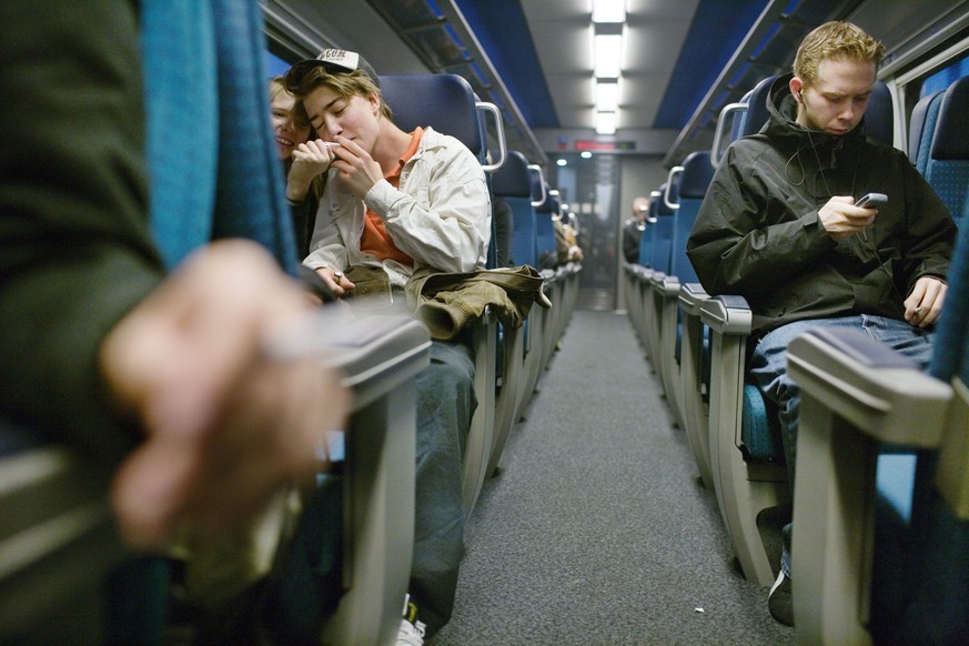People smoke cigarettes in a smoking compartment of a train from Zurich to Winterthur, Switzerland, on November 9, 2005. (KEYSTONE/Martin Ruetschi) 

Passagiere rauchen im Raucherabteil der SBB zwisch ...