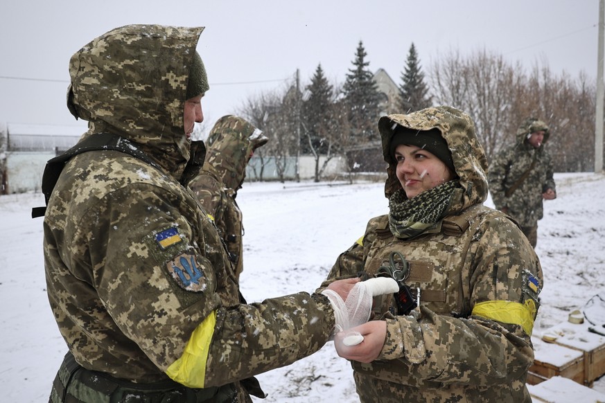 epa09785014 An Ukrainian serviceman gives medical aid to her colleague near the city of Kharkiv, Ukraine, 25 February 2022. Russian troops entered Ukraine on 24 February prompting the country&#039;s p ...