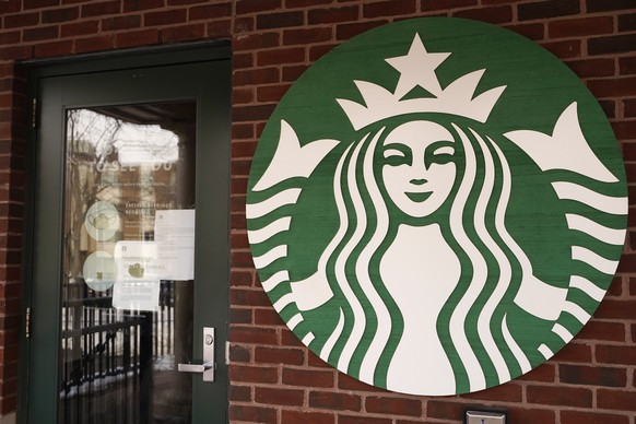 In this Jan. 6, 2021, photo, a Starbucks coffee company logo and information signs are seen at Palatine Metra train station in Palatine, Ill. Companies that would be affected by a Biden administration ...