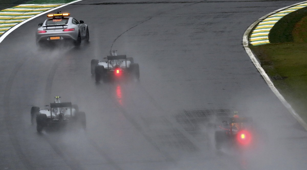 Formula One - F1 - Brazilian Grand Prix - Circuit of Interlagos, Sao Paulo, Brazil - 13/11/2016 - Mercedes' Lewis Hamilton of Britain (C) follows the safety car during a period of heavy rainfall  ...