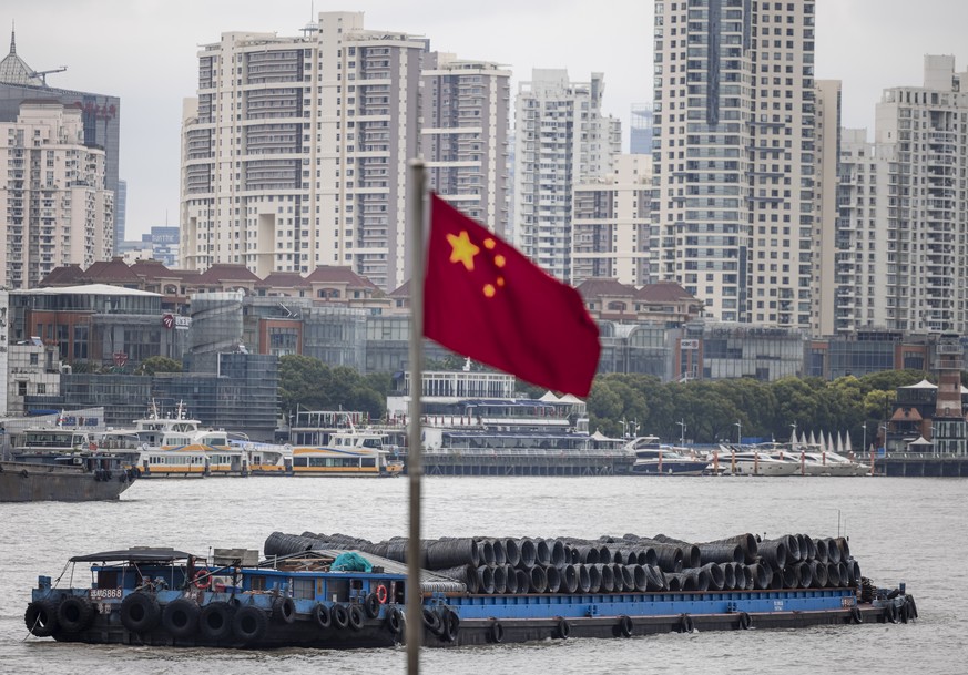 epa09416186 Cargo ships sail on the Huangpu River in front of the Lujiazui financial district in Shanghai, China, 16 August 2021. China?s economy continued to slow down in July, with the unemployment  ...