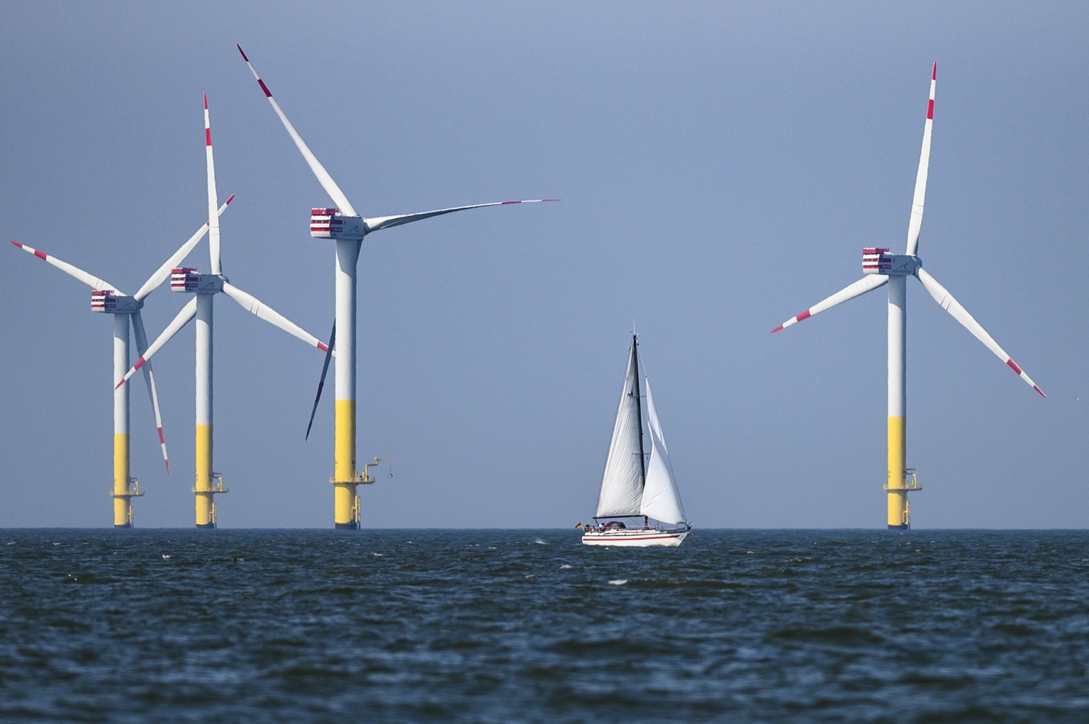 epa07753069 A sailing boat transits in front of the Offshore-Windpark Nordergruende, an offshore wind farm in the North Sea, Germany, 28 July 2019 (issued 02 August 2019). EPA/KARSTEN KLAMA