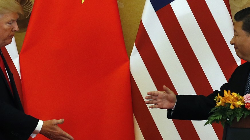 In this Nov. 9, 2017, photo, U.S. President Donald Trump, left, and Chinese President Xi Jinping prepare to shake their hands after a joint press conference at the Great Hall of the People in Beijing. ...