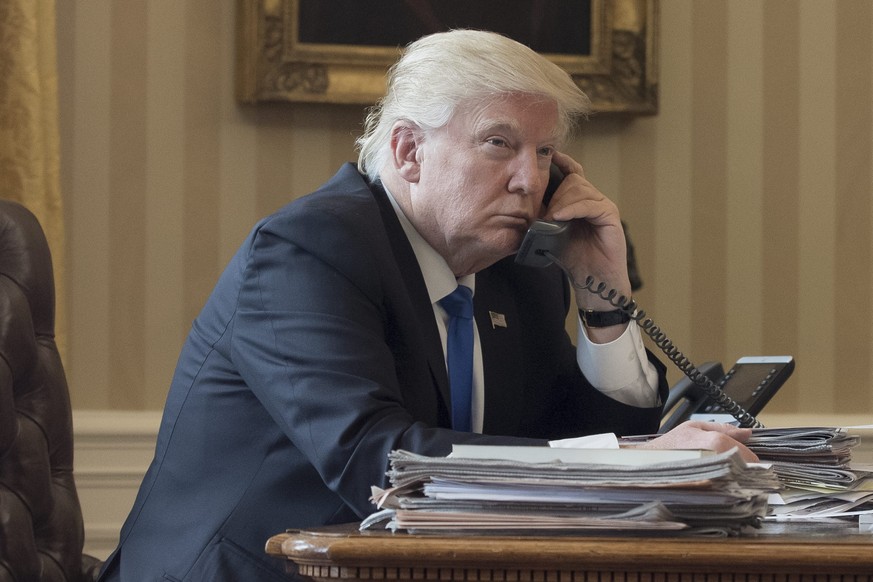 epa05757517 US President Donald J. Trump speaks on the phone with President of Russia Vladimir Putin, in the Oval Office of the White House in Washington, DC, USA, 28 January 2017. President Trump has ...