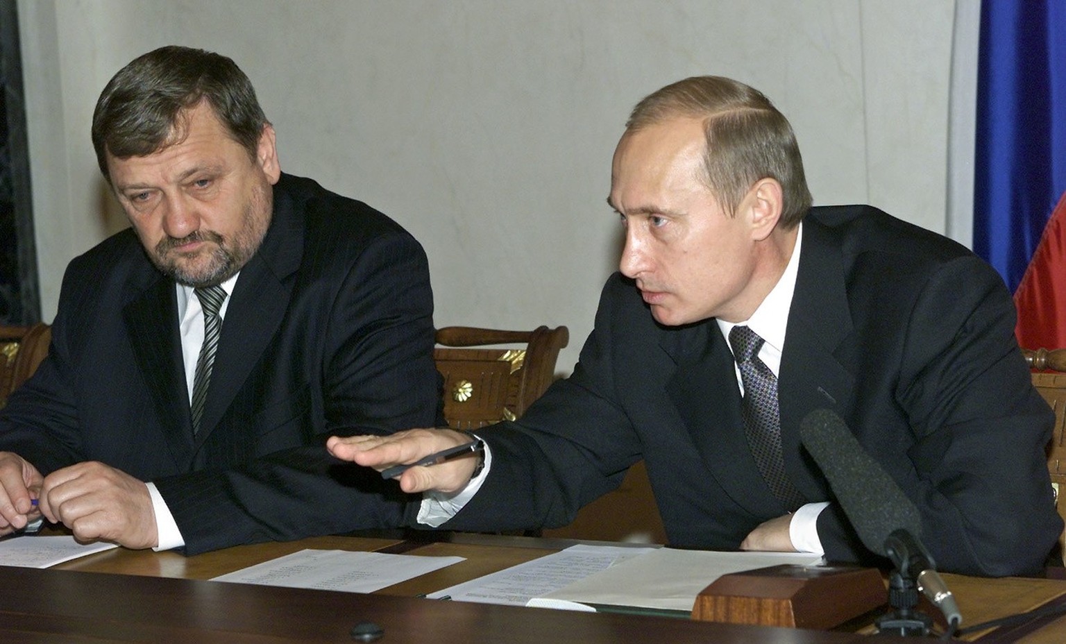 Russian President Vladimir Putin (R) is flanked by head of the Chechen government Akhmad Kadyrov (L) while delivering his speech during a meeting with a group of leading pro-Russian Chechen businessme ...
