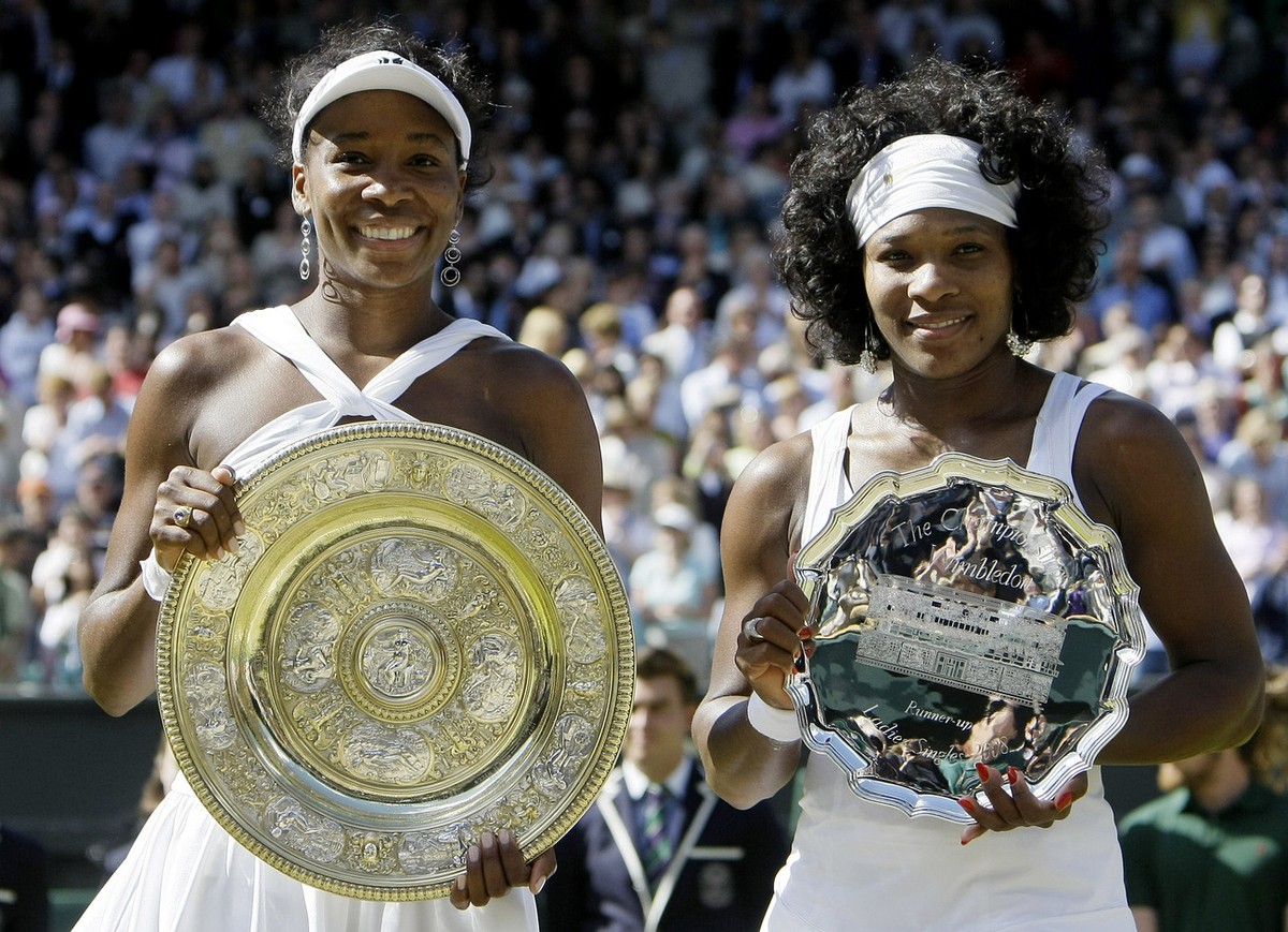 Venus Williams left, of the US holds her trophy after winning the women's singles final against her sister Serena right, on the Centre Court at Wimbledon, Saturday, July 5 , 2008. (AP Photo/Anja  ...