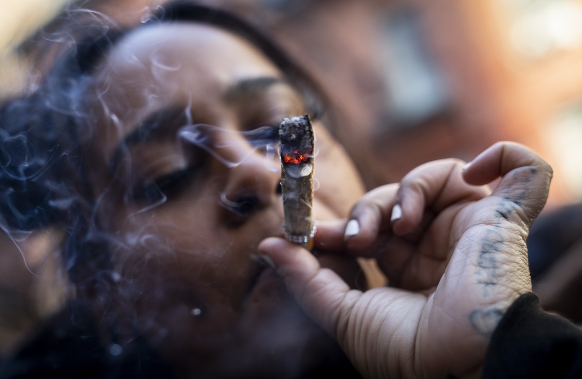 A person smokes cannabis outside the Smacked "pop up" cannabis dispensary location, Tuesday, Jan. 24, 2023, in New York. The store is the first Conditional Adult-Use Retail Dispensary (CAURD ...