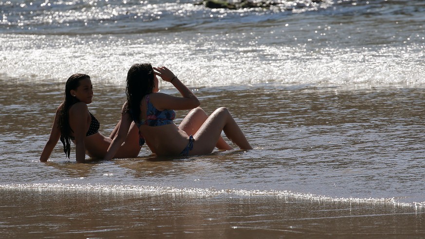 People sit on Biarritz beach, southwestern France, Saturday, May 30, 2020. Beaches in France have become partially accessible since the relaxing of lockdown measures put in place to prevent the spread ...