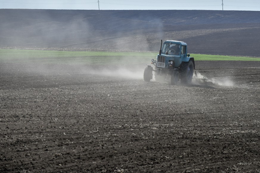 epa09922930 A farmer drives a tractor on the field in Khmelnytsky region, Ukraine, 02 May 2022. Russian troops invaded Ukraine on 24 February resulting in fighting and destruction in the country and t ...