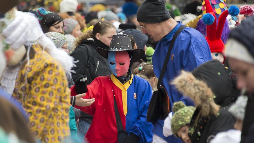 Ein Kind mit einem FCB-Kostuem bahnt sich seinen Weg durch die Massen und verteilt Suessigkeiten, an der Kinderfasnacht am zweiten der &quot;Drey scheenschte Daeaeg&quot; in Basel am Dienstag, 16. Feb ...