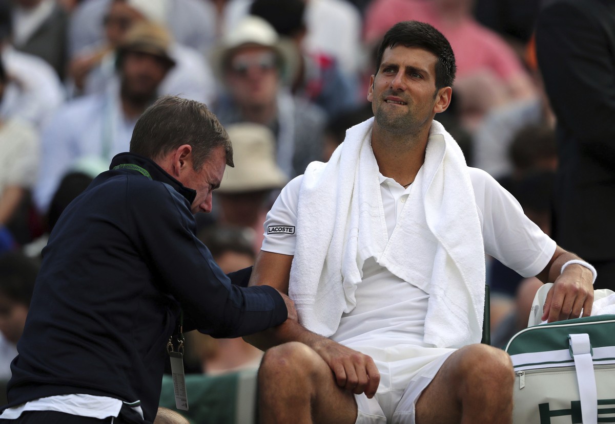 Serbia's Novak Djokovic receives medical treatment during his Men's Singles Match against Czech Republic's Tomas Berdych on day nine of the Wimbledon Tennis Championships at The All Eng ...