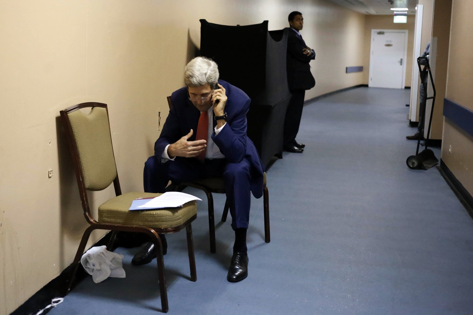 TOPSHOTS
U.S. Secretary of State John Kerry talks to Qatar&#039;s foreign minister Khaled al-Attiya (on the phone) on July 25, 2014, from a hallway in a hotel in the Egyptian capital, Cairo. Kerry en ...