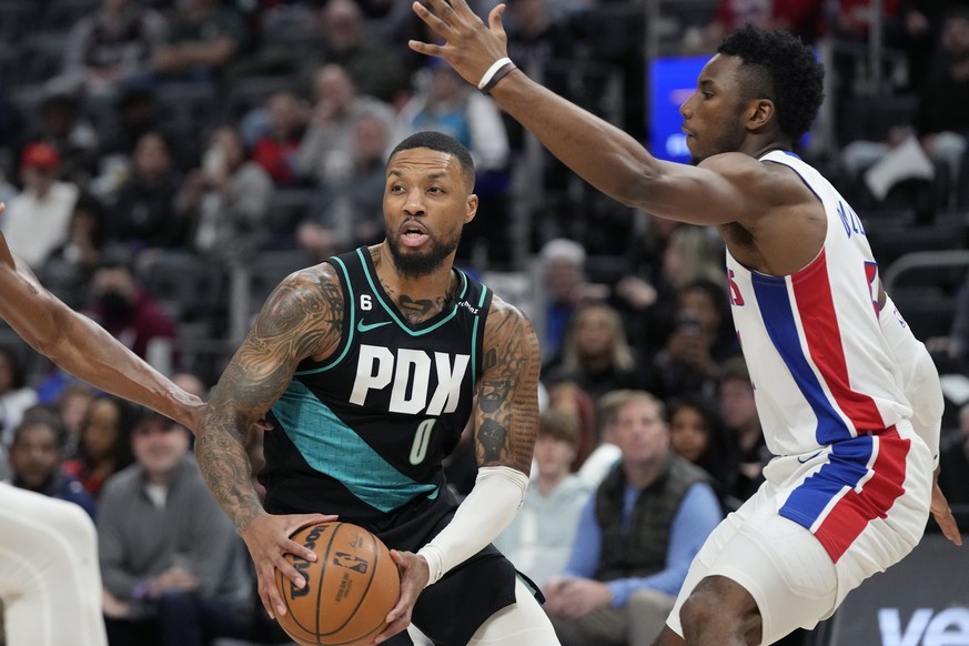 Portland Trail Blazers guard Damian Lillard looks to pass while Detroit Pistons guard Hamidou Diallo (6) defends during the first half of an NBA basketball game against the Detroit Pistons, Monday, March...