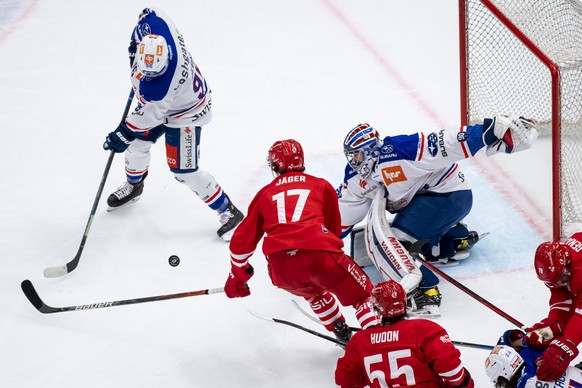 L&#039;attaquant lausannois Ken Jaeger, centre, lutte pour le puck avec le gardien zuerichois Ludovic Waeber, droite, lors du match du championnat suisse de hockey sur glace de National League entre l ...