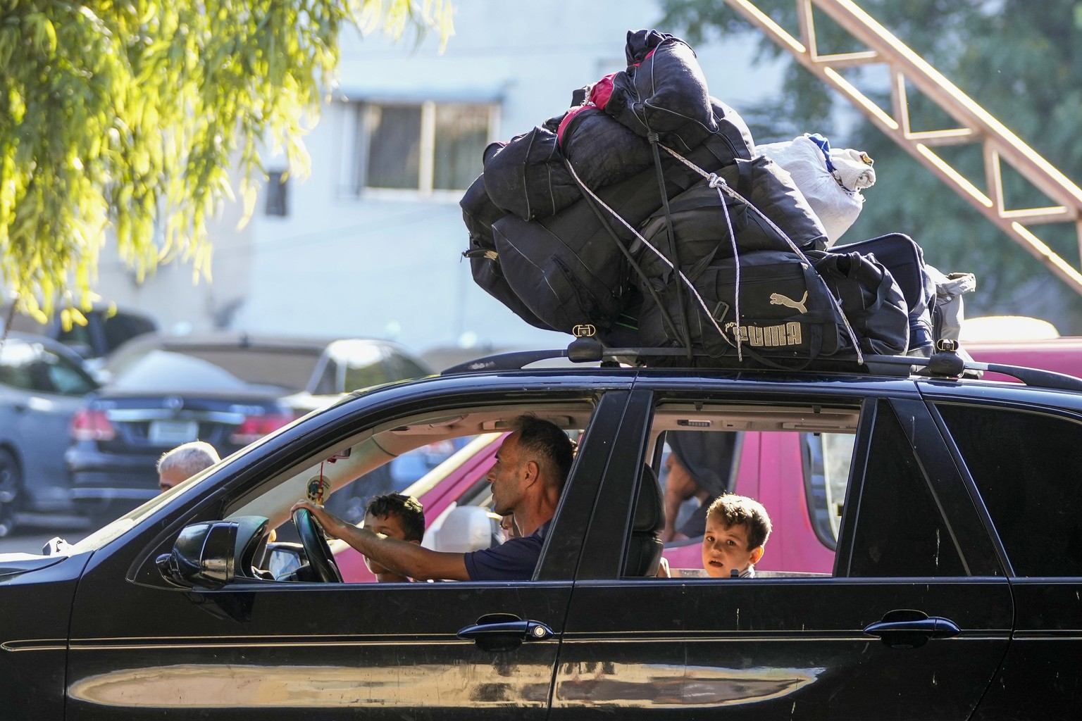 Residents who fled from southern villages amid ongoing Israeli airstrikes Monday drive with their belongings on top of their car in Beirut, Lebanon, Tuesday, Sept. 24, 2024. (AP Photo/Hassan Ammar)