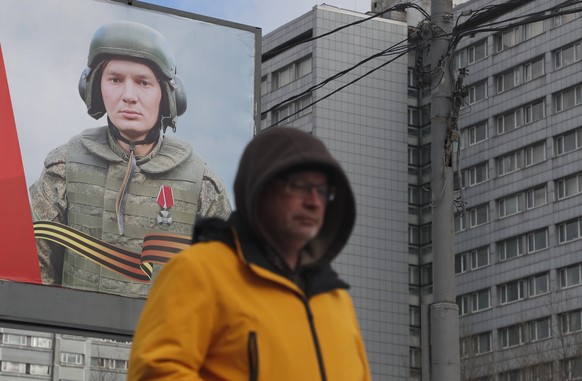 epa10496981 A man walks in front of a poster in support of Russian army in Moscow, Russia, 01 March 2023. The European Union on 25 February introduced the 10th package of sanctions against Russia. The ...
