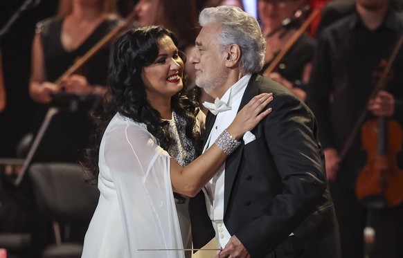 epa09475295 Russian-Austrian soprano Anna Netrebko (L) performs with Spanish tenor Placido Domingo (R) during gala concert at in the Kremlin Palace in Moscow, Russia, 18 September 2021, celebrating he ...