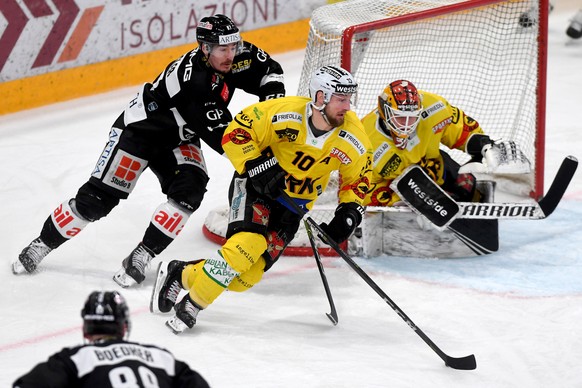 From left Lugano&#039;s player Dario Buergler, Bern&#039;s player Tristan Scherwey and Bern&#039;s goalkeeper Tomi Karhunen, during the preliminary round game of National League A (NLA) Swiss Champion ...