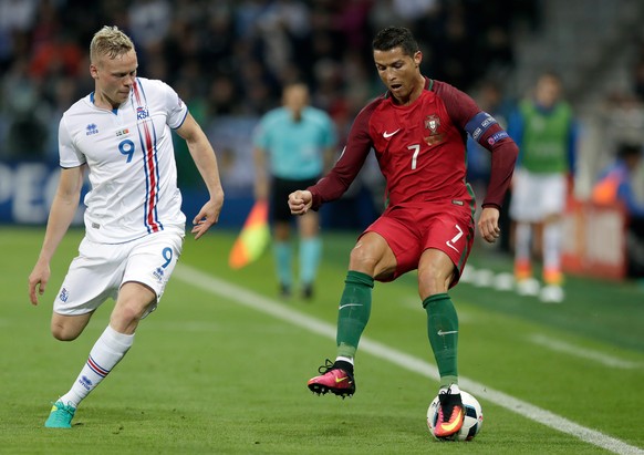 Portugal&#039;s Cristiano Ronaldo, right, drives the ball around Iceland&#039;s Kolbeinn Sigthorsson during the Euro 2016 Group F soccer match between Portugal and Iceland at the Geoffroy Guichard sta ...