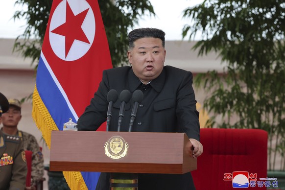 In this photo provided by the North Korean government, North Korean leader Kim Jong Un speaks as he visits an air force helicopter unit to praise the troops for helping rescue people from recent flood ...