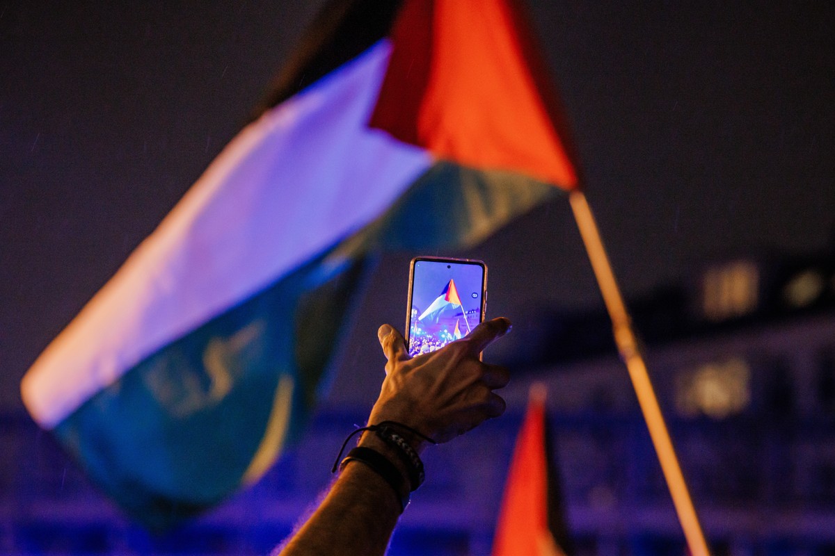 epaselect epa10945749 A participant films a Palestinian flag with his mobile phone during a protest in solidarity with people in Gaza, in Kreuzberg district of Berlin, Germany, 28 October 2023. Variou ...