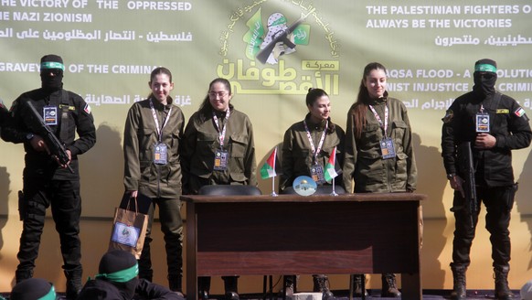 epaselect epa11851213 (L-R) Israeli hostages Naama Levy, Liri Albag, Daniella Gilboa and Karina Ariev stand on a stage before being delivered to the representative of the International Committee of th ...