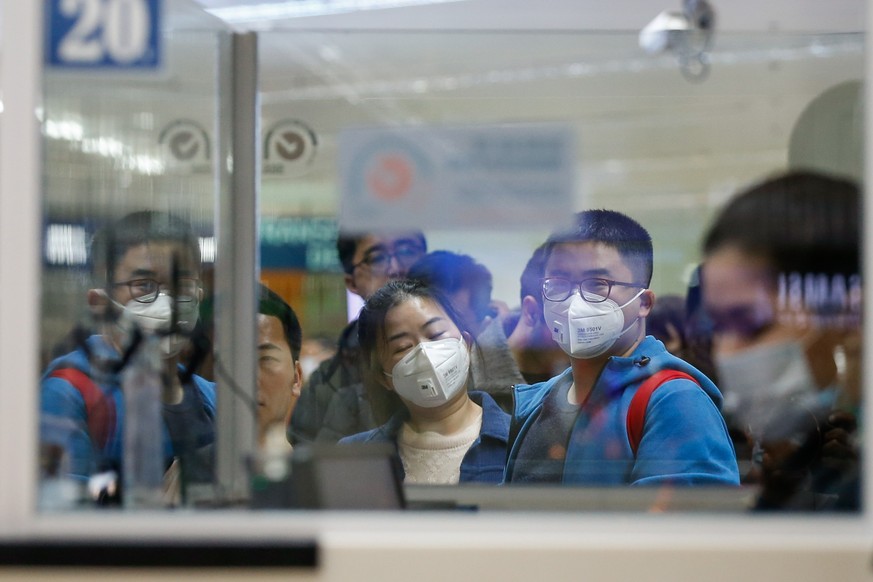 epa08149567 Passengers wearing face masks who arrived from Guangzhou, China lineup for immigration at the Ninoy Aquino International Airport in Manila, Philippines, 22 January 2020. According to media ...