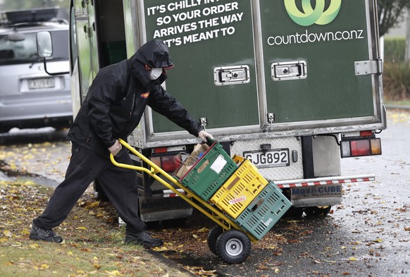 A delivery driver wearing a face mask delivers groceries to a home in central Christchurch Monday, March 30, 2020. New Zealand is into day five of a minimum 28 day lockdown in a bid to stop the spread ...