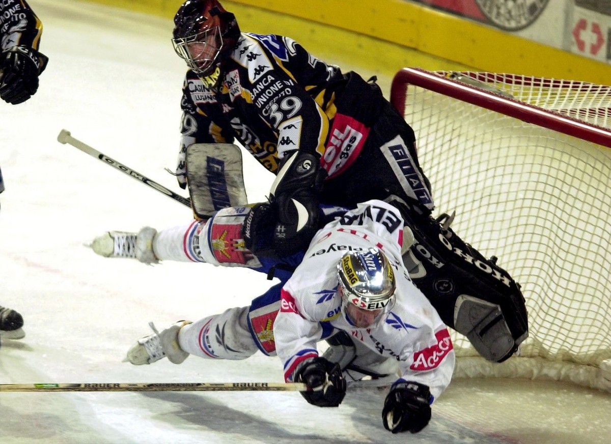 ZSC Lions' Michel Zeiter, unten, fliegt am 5. April 2001 im 6. Playoff Finalspiel zwischen den ZSC Lions und dem HC Lugano in Zuerich gegen den Torhueter des HC Lugano, Christobal Huet. (KEYSTONE ...