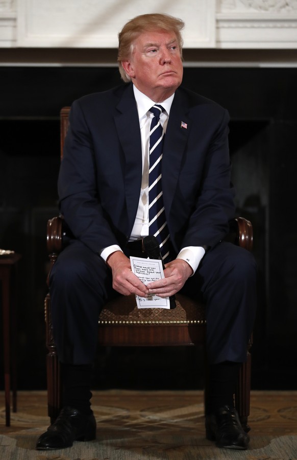 President Donald Trump holds notes during a listening session with high school students and teachers in the State Dining Room of the White House in Washington, Wednesday, Feb. 21, 2018. Trump heard th ...