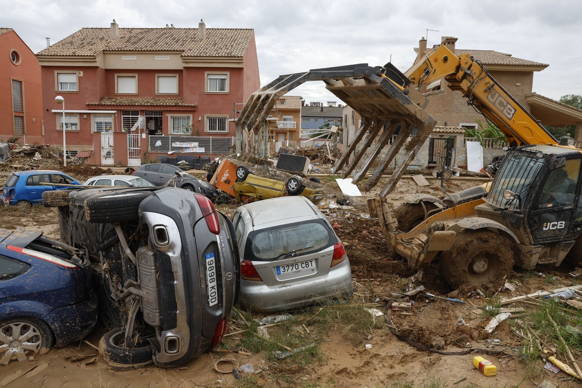 epa11716592 A bulldozer removes damaged cars in the flood-hit municipality of Paiporta, province of Valencia, Spain, 12 November 2024. The floods in Valencia and neighboring provinces have caused at l ...